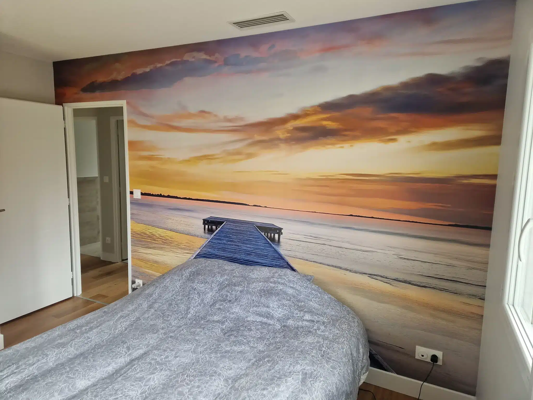 Papier peint panoramique coucher de soleil sur un ponton posé derrière un lit