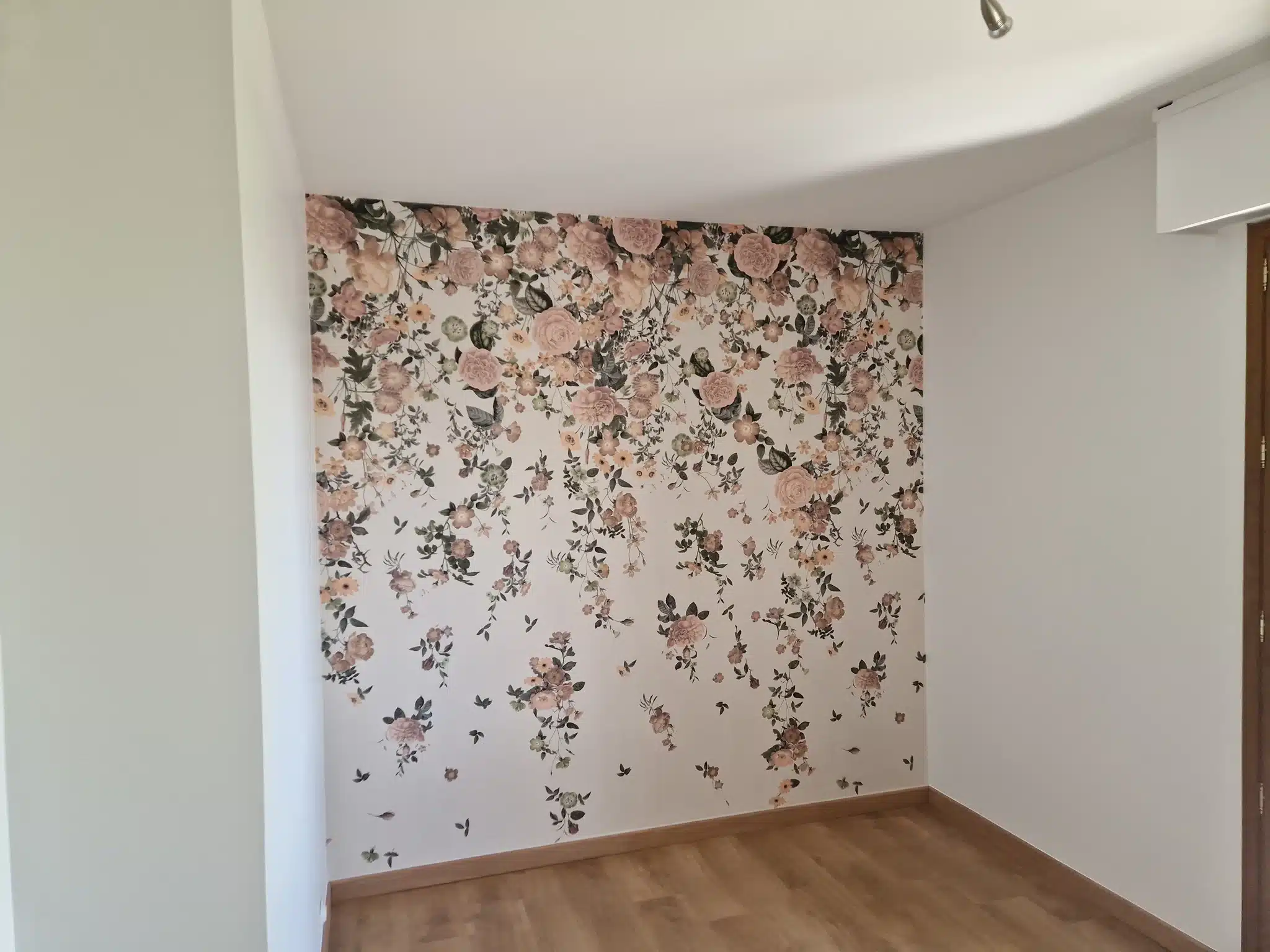 Papier peint à motif floral rose posé sur un pan de mur