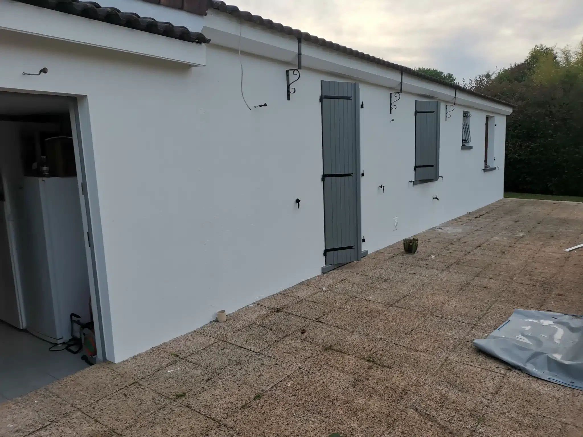 Façade de plain-pied repeinte en blanc avec volets gris