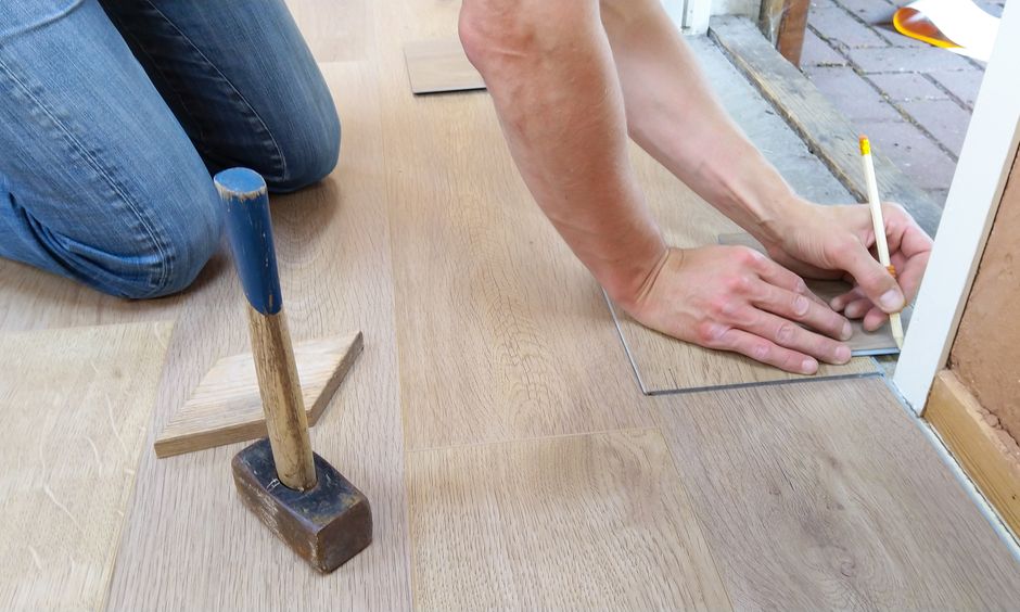 Traçage d'une lame de sol avant découpe, maillet posé à côté