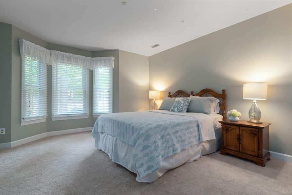 Chambre lumineuse au sol recouvert d'une moquette beige